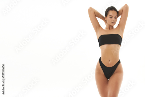 Healthy girl with toned slim body, soft skin and elastic buttocks, thighs in black bikini panties, sexy back, narrow big ass in underwear. Beautiful female body in shape.
