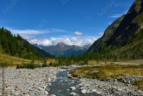Stream flowing through Gradenmoos basin in Gradental valley in Schober group sub-range of Hohe Tauern in Central Eastern Alps, Carinthia, Austria and the peak of Stanziwurten peak in Goldberg Group