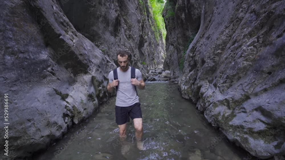 Barefoot man walking in creek between cliffs.
Free and adventurous young man walking barefoot with his backpack on the creek.
Barefoot man walking in creek between cliffs.
Free and adventurous young man walking barefoot with his backpack on the creek.
