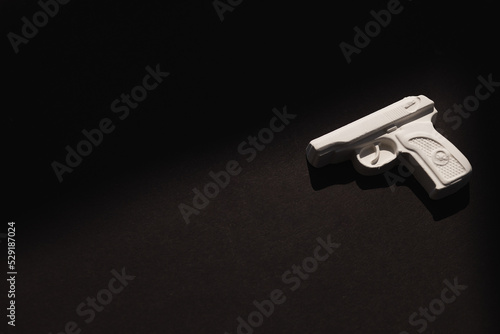 Plaster figure of a gun on a colored background