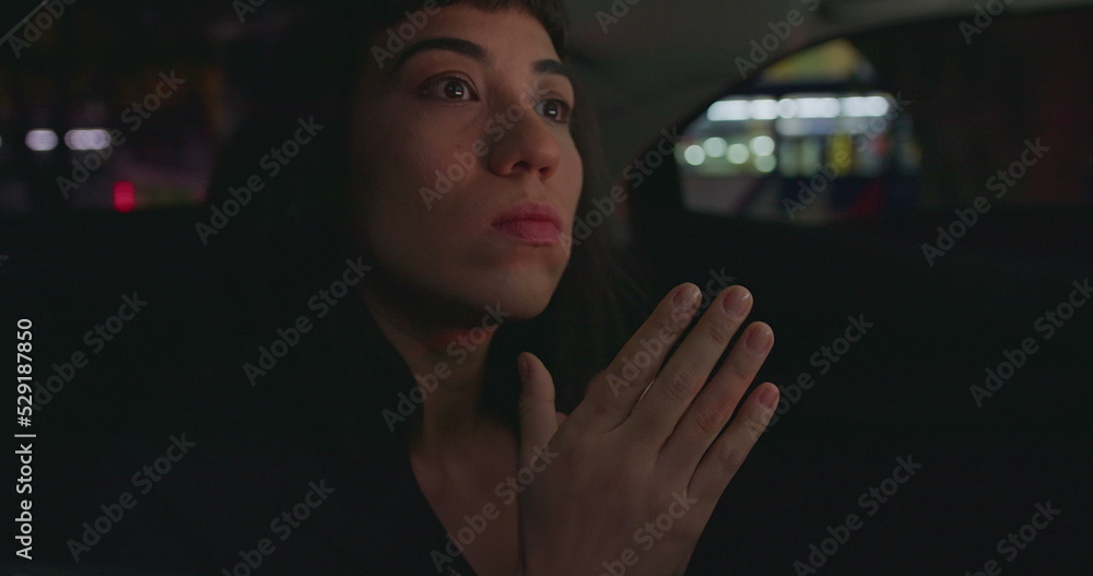 Anxious female passenger late for meeting in the backseat of a car