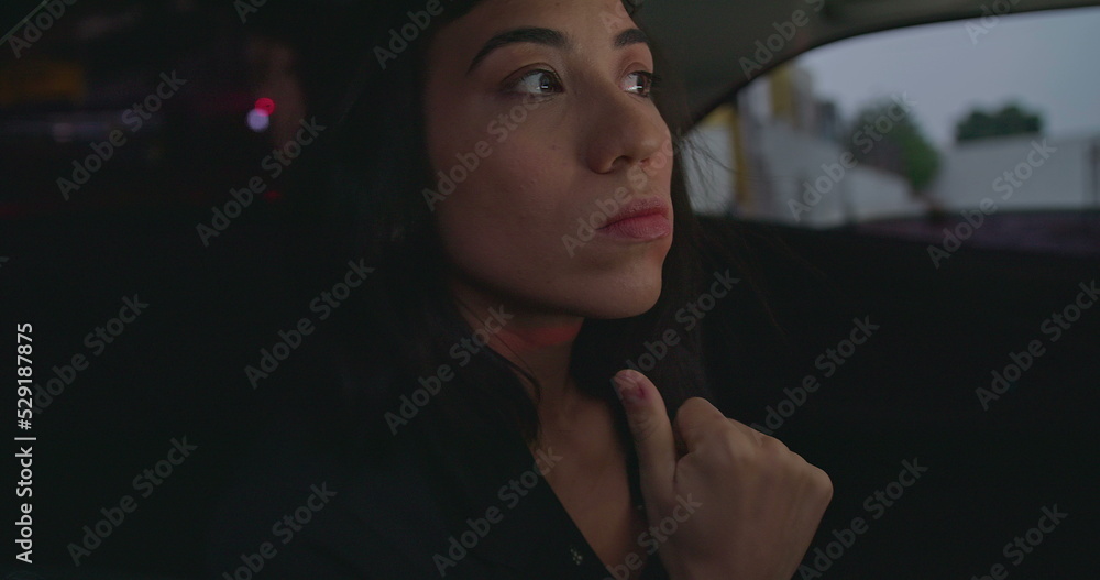 Anxious female passenger late for meeting in the backseat of a car