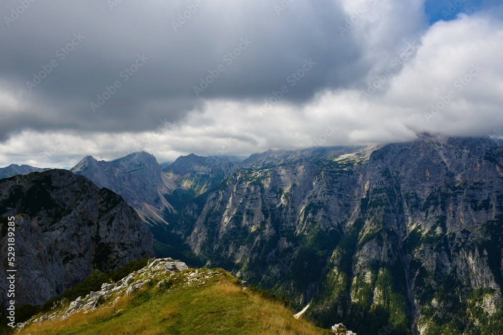 View of Krma valley and the mountains above with Triglav mountain covered in clouds in Julian alps and Triglav national park, Slovenia