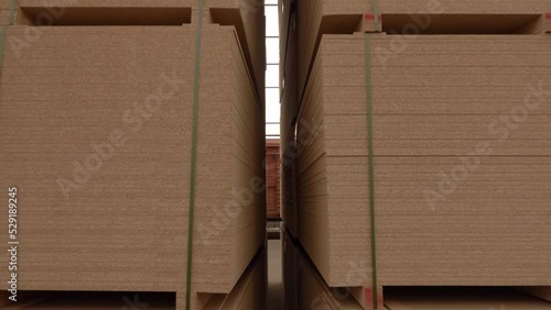 mdf boards and chipboards storing at factory, production, manufacture and woodworking industry concept - chipboards processing. the camera between the rows of chipboard goes back