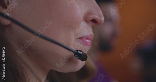 Closeup of female telemarketer speaking on headset. Woman lips and mouth speaking with client or customer at telemarketing call center support. Person talking with microphone