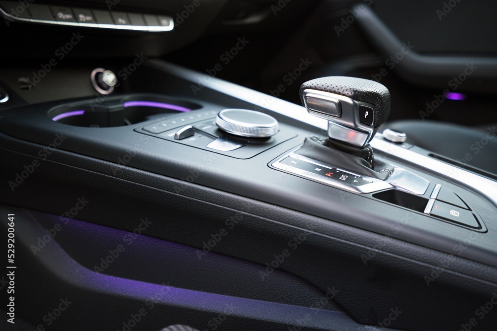 gear shifter knob inside a luxury car with purple neon lights. car interior and high end photography.