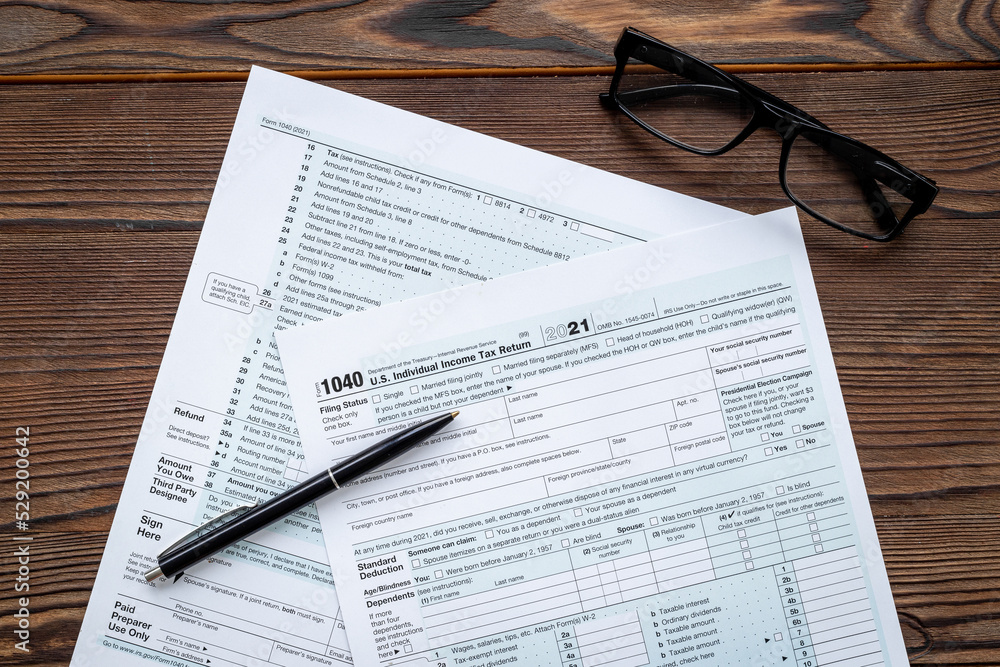 Fototapeta premium Businessman table with US tax form and pen. Culculating and payment of taxes