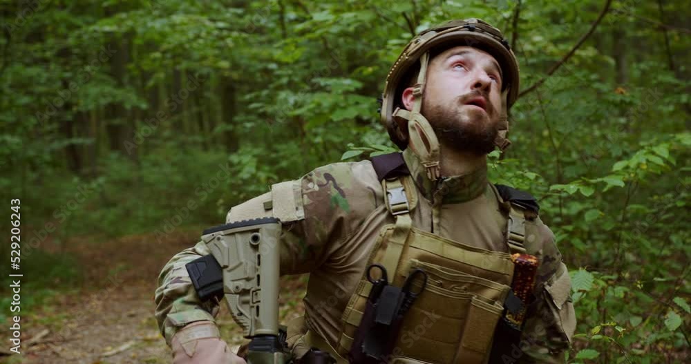 The soldier in the forest stands on his trips and dramatically closes his eyes with up. The despair of a Ukrainian soldier. The military in the ammunition is tired. The soldier in the forest stands on his trips and dramatically closes his eyes with up. The despair of a Ukrainian soldier. The military in the ammunition is tired.