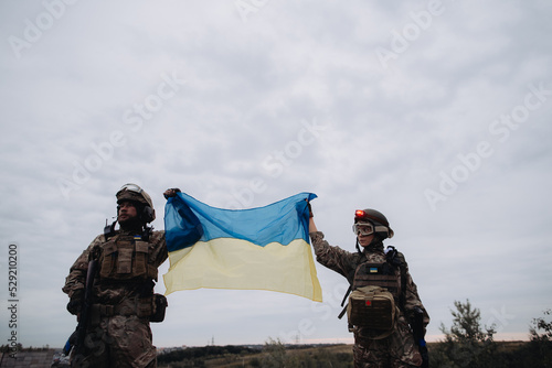 Ukrainian military holds the flag of Ukraine. The concept of victory. The war between Ukraine and Russia. photo