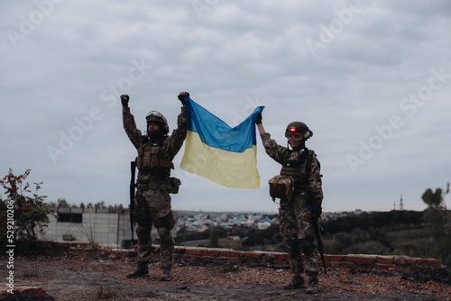 Quadro su tela Ukrainian military holds the flag of Ukraine