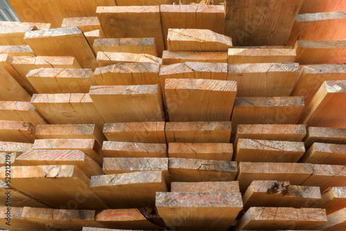 Wooden boards are stacked in a sawmill or carpentry shop. Sawing drying and marketing of wood. Industrial background