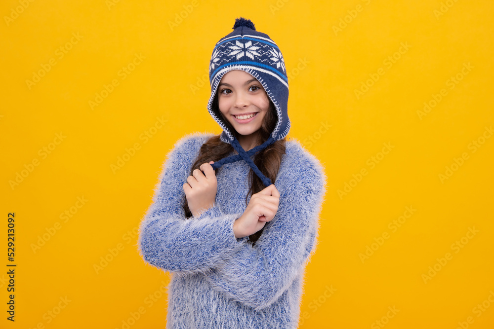 Winter hat. Cold season concept. Winter fashion accessory for children. Teen girl wearing warm knitted hat. Happy face, positive and smiling emotions of teenager girl.