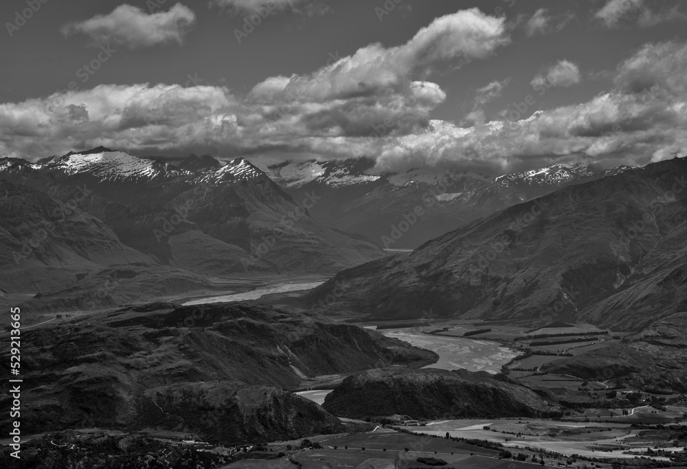 A Black and White view on snowy mountain scenery, fields and hills, a river and Lake Wanaka from Roys Peak, Wanaka, South Island, New Zealand