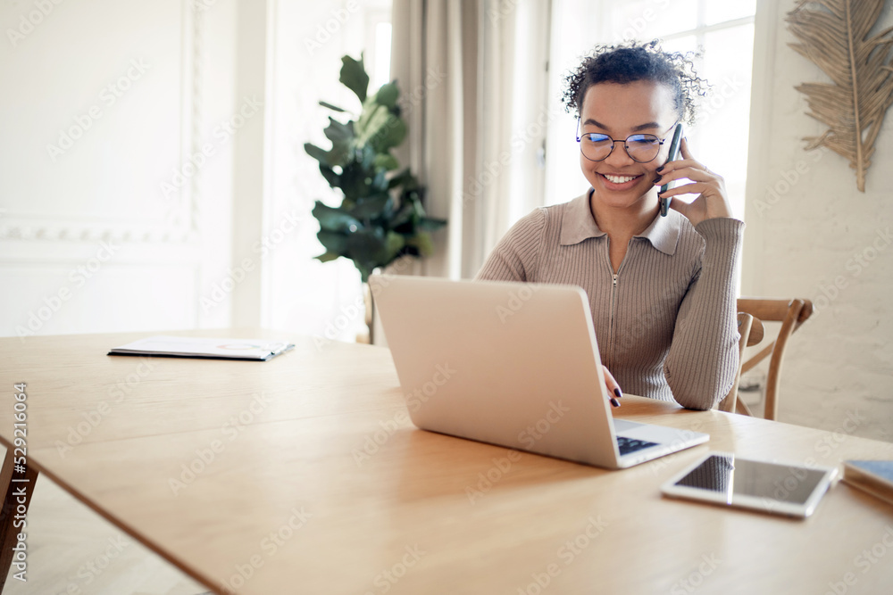 Female manager uses laptop on desk chat online video call working with documents in new office Female manager uses laptop on desk chat online video call working with documents in new office