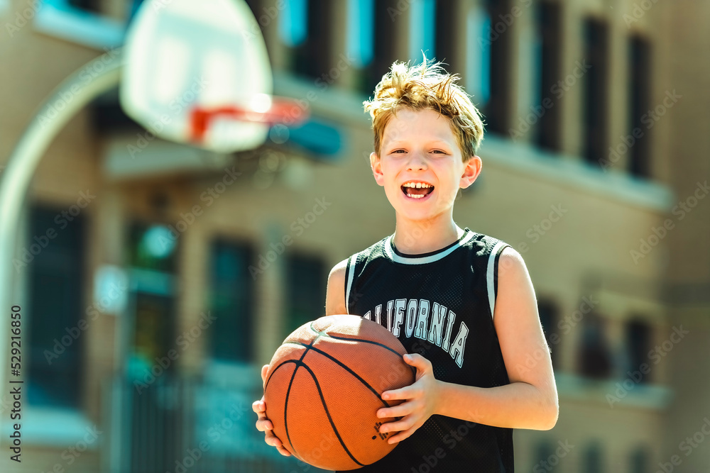portrait of a boy kid playing with a basketball in park portrait of a boy kid playing with a basketball in park