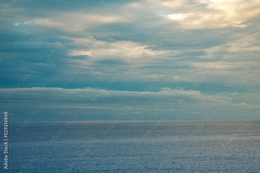 Calm sea with cloudy sky at sunset. Panorama of the Mediterranean sea in Liguria