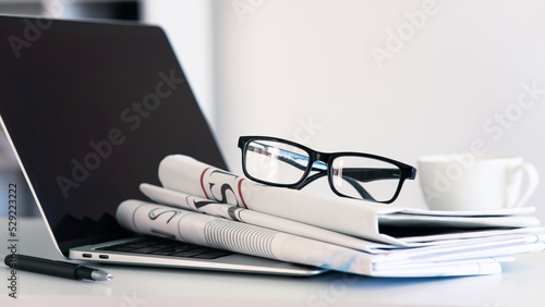 Newspaper with computer on table