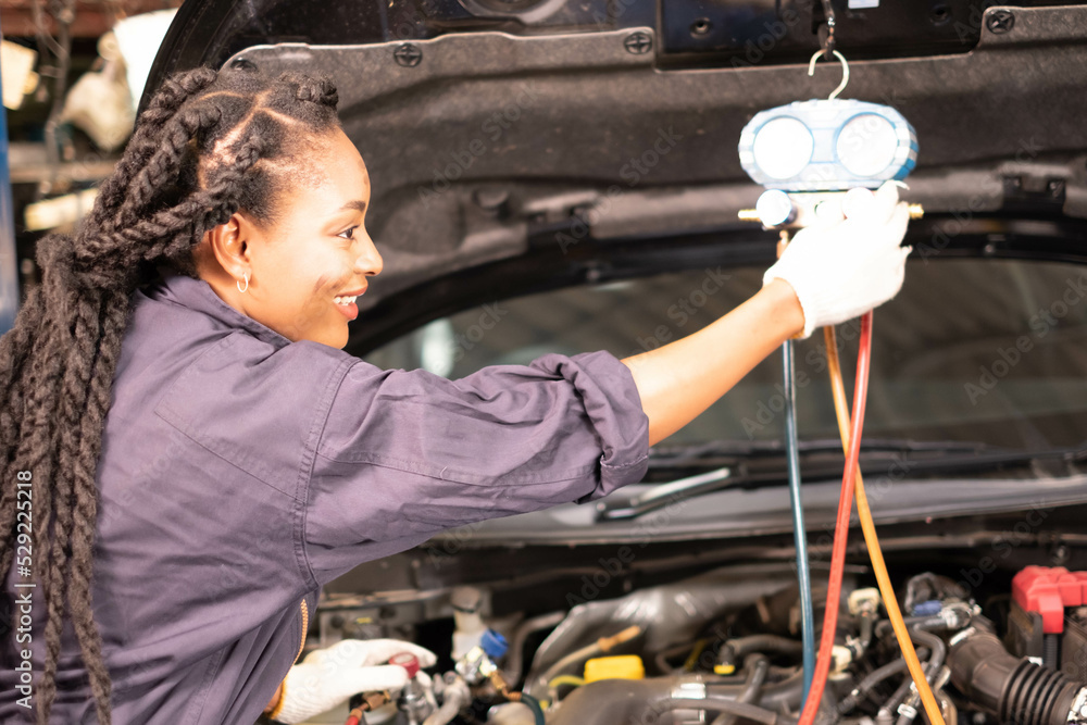 Portrait of a confident African American woman Mechanic in the garage. Auto mechanic working in garage,