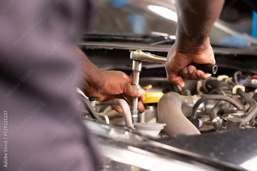 Auto mechanic working and repair on car engine in mechanics garage. Car service. male mechanic repairs car in garage. Car maintenance and auto service garage concept. Auto mechanic working and repair on car engine in mechanics garage. Car service. male mechanic repairs car in garage. Car maintenance and auto service garage concept.