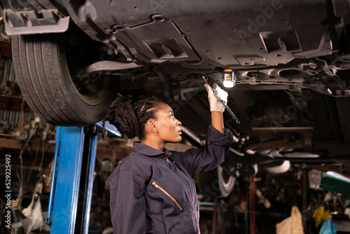African american Two mechanics - man examining car engine. Auto mechanic working in garage.Car Mechanic Detailed Vehicle Inspection. Auto Service Center Theme.