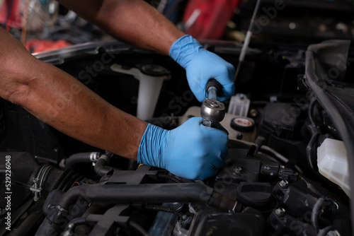 Auto mechanic working and repair on car engine in mechanics garage. Car service. male mechanic repairs car in garage. Car maintenance and auto service garage concept. © Montri