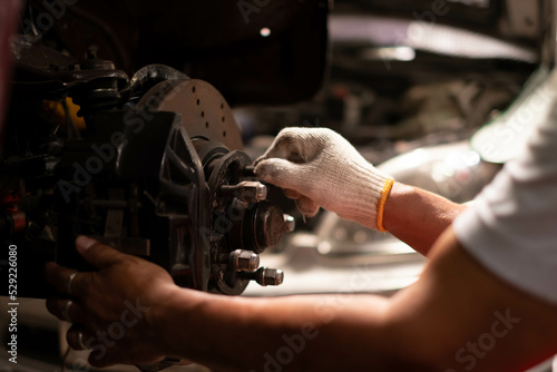 Auto mechanic working and repair on car engine in mechanics garage. Car service. male mechanic repairs car in garage. Car maintenance and auto service garage concept.
