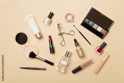 Different makeup products on color background, top view