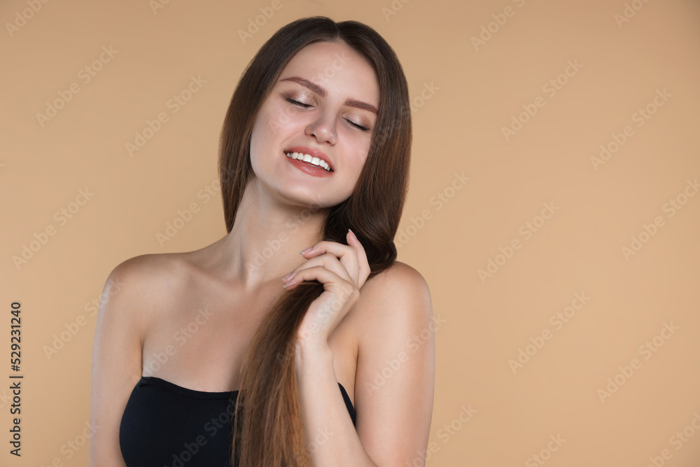 Young woman with strong healthy hair on beige background, space for text Young woman with strong healthy hair on beige background, space for text