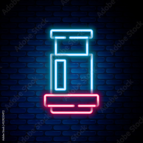 Glowing neon line Aeropress coffee method icon isolated on brick wall background. Device for brewing coffee. Colorful outline concept. Vector