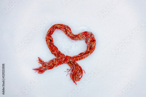 Valentine's day and winter season concept, knitted warm scarf in the snow in the shape of a heart, I love winter