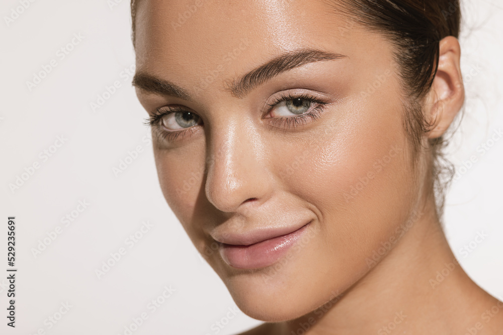 Naklejka premium Closeup portrait of beautiful young girl with clean well-kept skin isolated over white background. Skin care. Facial treatment. Cosmetology, beauty and spa.