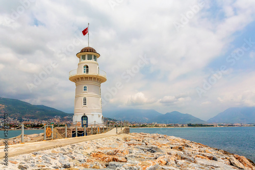The old lighthouse in the port of the Turkish city of Alanya at sunny summerday with butiful clouds at background photo
