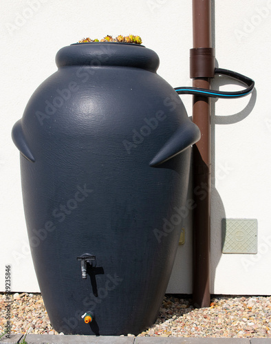 Rainwater barrel connected to the gutter, water saving concept