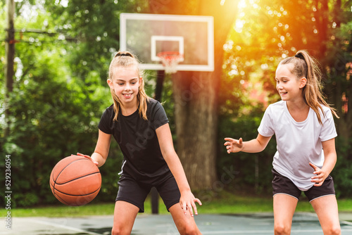 two girl child in sportswear playing basketball game © Louis-Photo