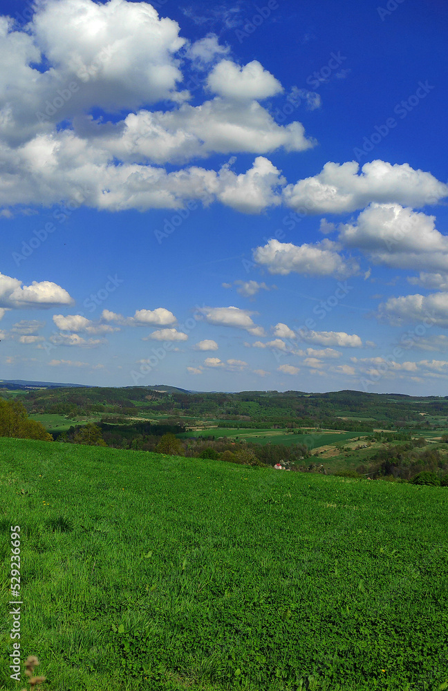 view of the green rural farmland and country road with beautiful clouds