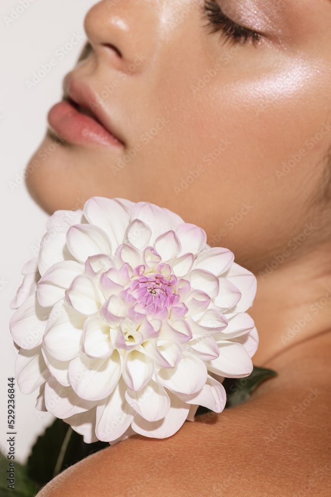 Beauty portrait of charming young girl with flower isolated over white studio background. Cosmetics, natural beauty and aesthetic cosmetology concept. Beauty portrait of charming young girl with flower isolated over white studio background. Cosmetics, natural beauty and aesthetic cosmetology concept.