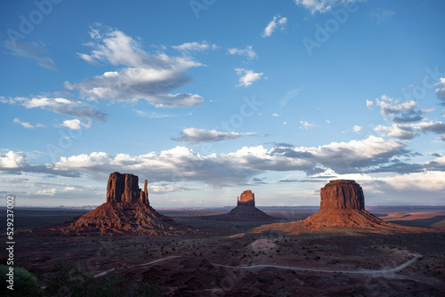 Panoramic view over the freestanding rocks in Monument Valley  which are illuminated by the last evening light and rise from the dark steppe.