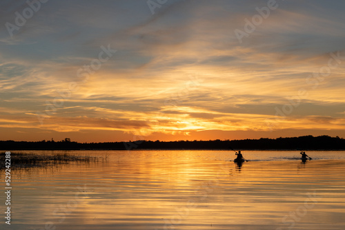 Kayaks on lake at sunset silhouette