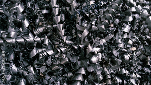 Steel scrap materials recycling. Aluminum chip waste after machining metal parts on a cnc lathe. Closeup twisted spiral steel shavings. Small roughness sharpness, possible granularity, blurred focus
