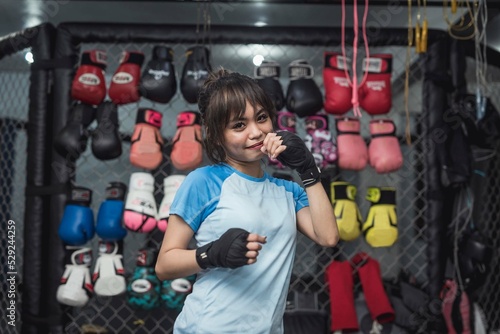 Φωτογραφία A female athlete holding both of her fists in front of her face while grinning playfully for the camera
