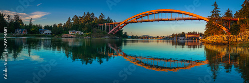 Panoramic landscape of Rainbow Bridge and mirror reflections on the Swinomish Channel near Skagit Bay in La Conner of Washington State
