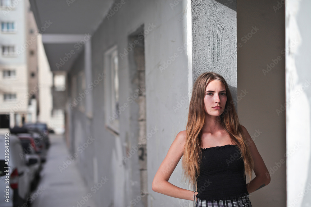 portrait of young woman leaning against a wall in the city portrait of young woman leaning against a wall in the city
