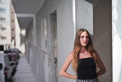 portrait of young woman leaning against a wall in the city