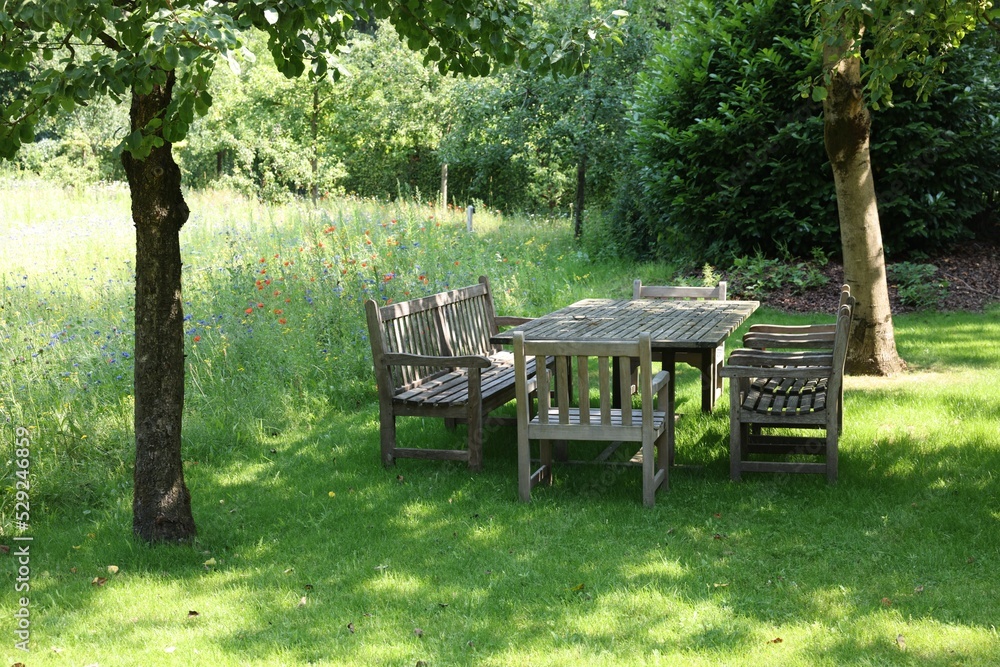 Empty wooden table with bench and chairs in garden Empty wooden table with bench and chairs in garden