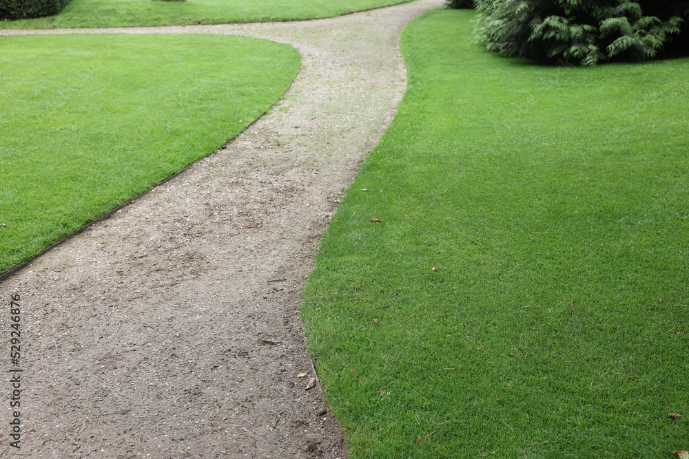 Pathway surrounded by beautiful green lawn outdoors. Landscape design Pathway surrounded by beautiful green lawn outdoors. Landscape design