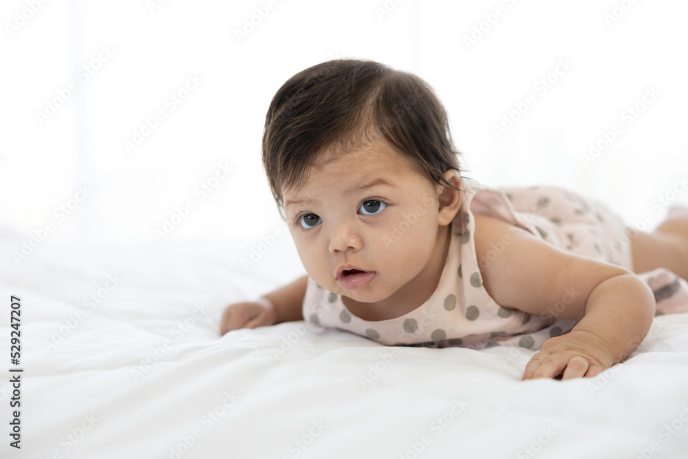portrait cute baby crawling on bed and looking to something portrait cute baby crawling on bed and looking to something