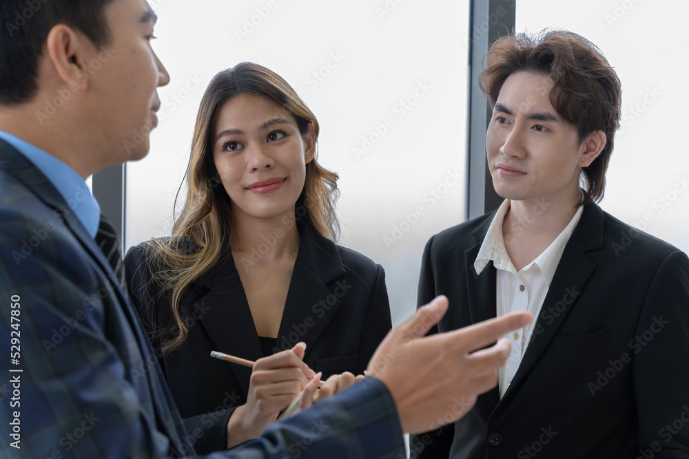 A group of young Asian businessmen Talking and planning work happily and have fun. at the company's office A group of young Asian businessmen Talking and planning work happily and have fun. at the company's office