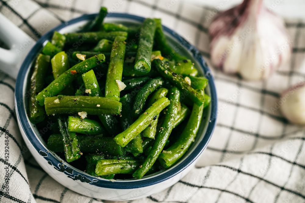 Baked green beans in a dish on a linen towel - obrazy, fototapety, plakaty 