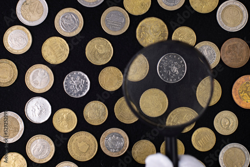 Coins and a magnifying glass on a black cloth