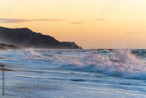 Wellen im Mettelmeer bei Sonnenuntergang am Strand Spiaggia di Scivu auf Sardinien Italien